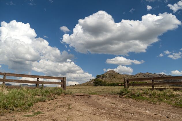 纹理多云的天空下有一个敞开的木栅栏的山谷景观乡村自然田野