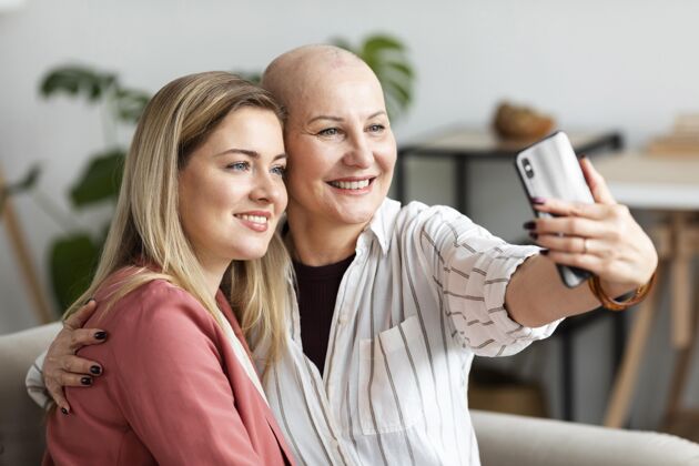 保健患有皮肤癌的中年妇女和她的朋友在一起疾病秃头疾病