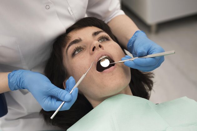 工作年轻的女病人在正畸医生那里做牙科手术医疗专业正畸