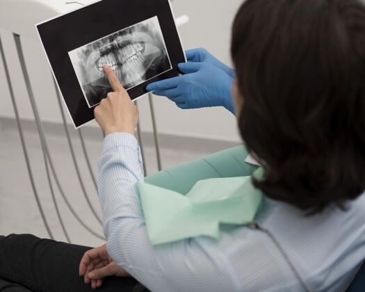 雇员女病人和牙医一起看牙齿的X光片职业就业病人