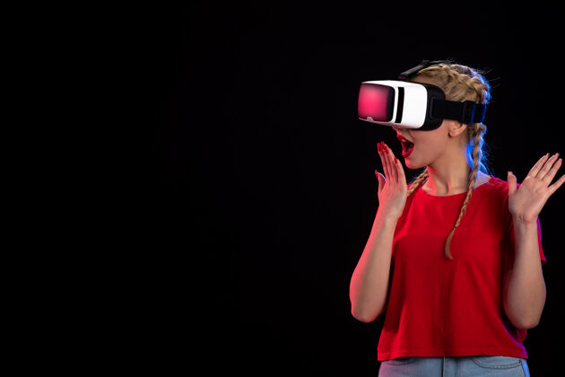 黑暗年轻女性在黑暗的墙上玩虚拟现实的正面图游戏虚拟现实视图