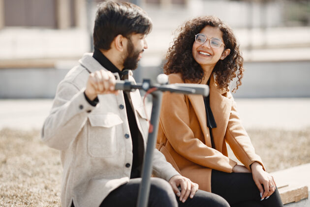 女性欧洲女孩阿尼迪亚男孩骑摩托车和微笑街道Escooter女人