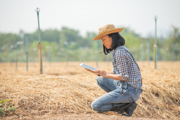 质量控制聪明的农场美丽的农民用平板电脑控制她的农场和生意 开心而微笑商业和农业概念农民或农艺师检查准备种菜的地块在线农场亚洲