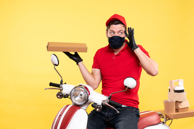 食物正面图：戴着面罩骑自行车的男性快递员 黄色食品盒盒子摩托车工作