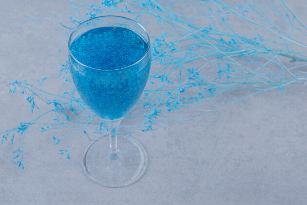 利口酒蓝色的自制鸡尾酒在灰色的表面玻璃酒吧马提尼