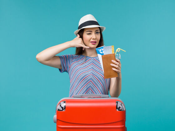 微笑前景度假中的女人拿着蓝色背景的船票航行旅行女海飞机夏天休闲航行美丽