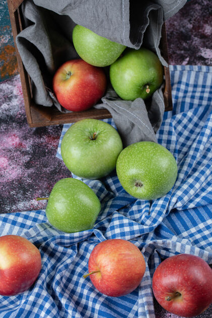 蓝色红色和绿色的苹果在格子毛巾上浅色食物多汁