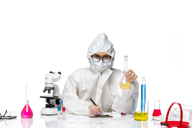 实验室外套正面图穿着特殊防护服的年轻女化学家拿着白色背景上的溶液烧瓶实验室的病毒化学医生防护保温瓶