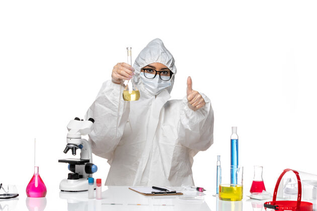 保温瓶正面图身穿特殊防护服的年轻女化学家拿着装有淡白色背景溶液的烧瓶实验室病毒化学防护溶液实验室外套