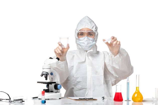 保温瓶正面图：年轻女医生穿着防护服 戴着口罩 白色背景上有一个装着柯维德病毒的瓶子 溅起大流行的柯维德病毒专业医生套装