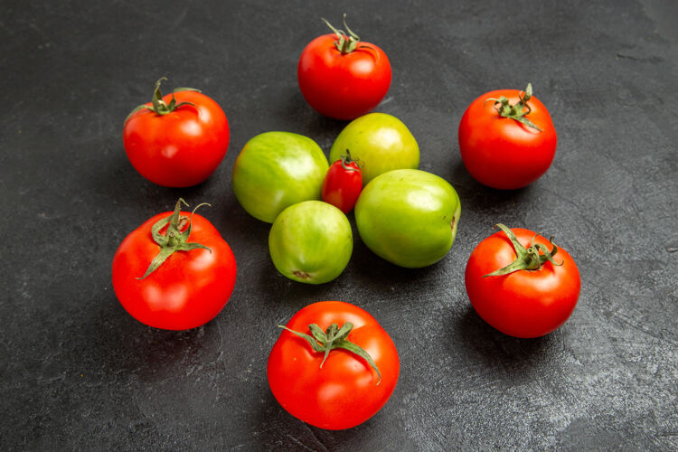 配料底图红色和绿色的西红柿围绕一个樱桃西红柿在黑暗的背景周围水果西红柿
