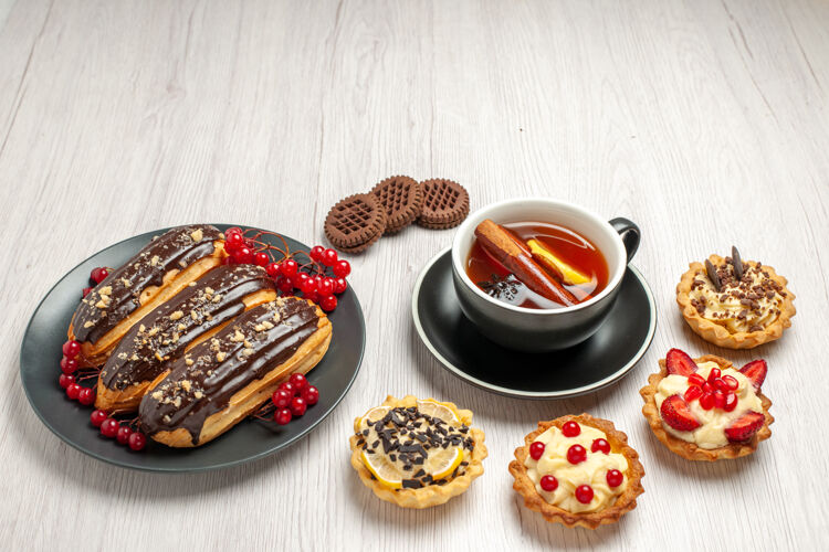 茶灰色盘子上的巧克力和葡萄干 白色木桌上的甜饼和柠檬肉桂茶 俯视图晚餐肉桂一餐