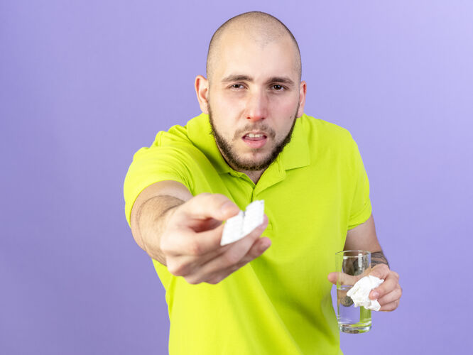 医学脸色苍白的年轻白种人手里拿着一包药片和一杯紫色的水疾病年轻包装