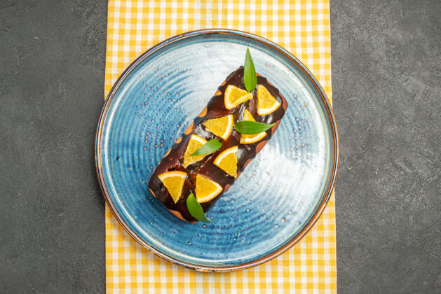 打火机黄色条状毛巾上装饰着柠檬和巧克力的美味蛋糕俯视图巧克力食物膳食