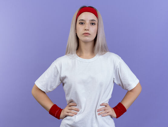 腕带自信的年轻白人运动女孩戴着背带和头带头带腰背带