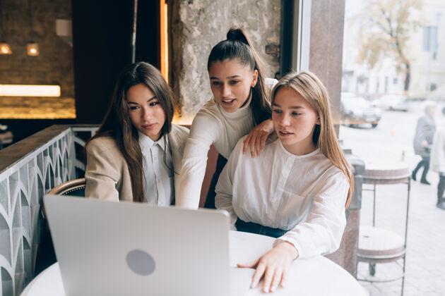 咖啡一群女朋友在咖啡馆里看一台笔记本电脑预订女性上网本