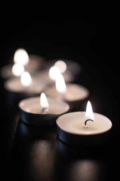 黑在漆黑的表面燃烧蜡烛的正面图符号正面表面