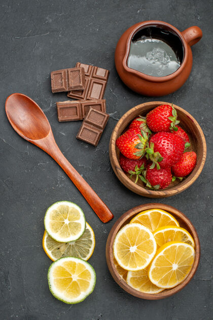灰色顶视图新鲜水果草莓和柠檬在灰色的表面美味过滤器勺子
