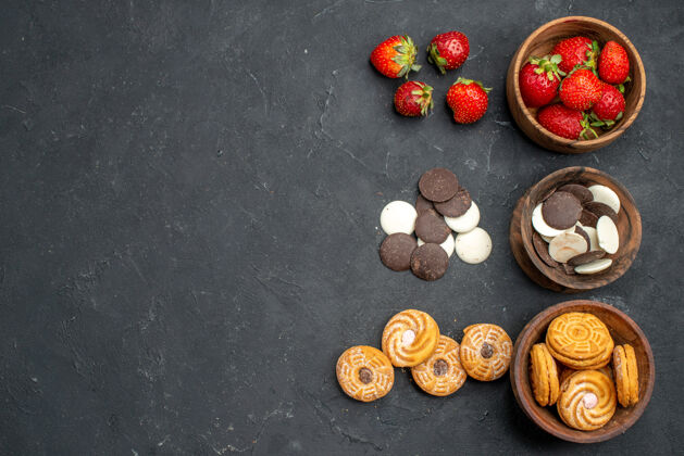 巧克力饼干俯瞰巧克力饼干与草莓和饼干在黑暗的表面坚果深色种子