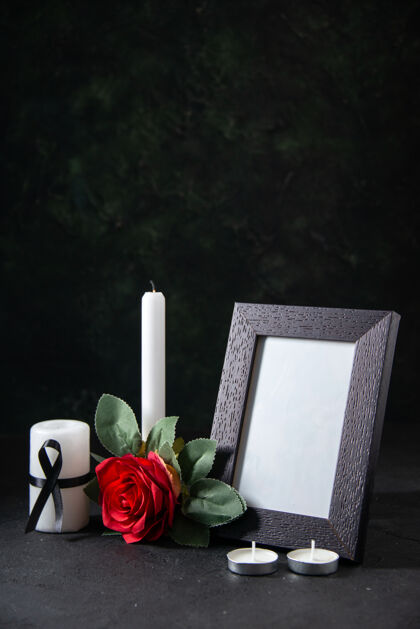 蜡烛前视图白色蜡烛与相框和花在黑暗的表面风景框架黑暗