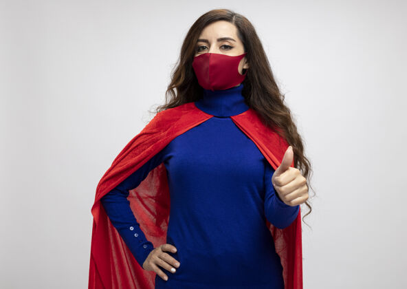 拇指自信的高加索超级英雄女孩 穿着红色斗篷 戴着红色防护面具超级英雄自信斗篷