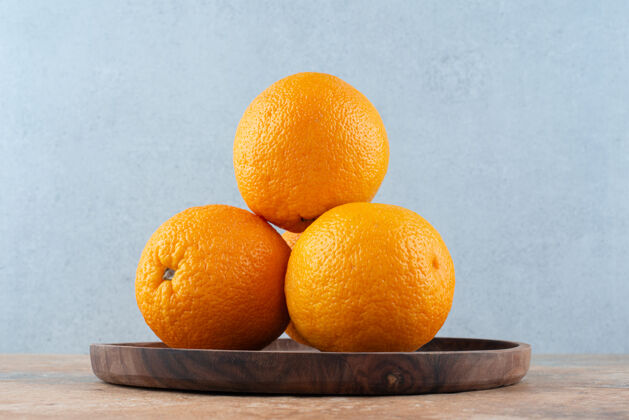 生的把新鲜的酸橙子放在木盘上黄色柑橘自然