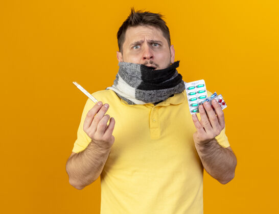 药片困惑的年轻金发病斯拉夫男子用围巾捂住嘴体温计医学男人