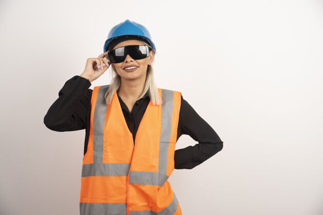 安全帽微笑的女建筑工人与护目镜和头盔摆姿势高品质的照片女性女士头盔