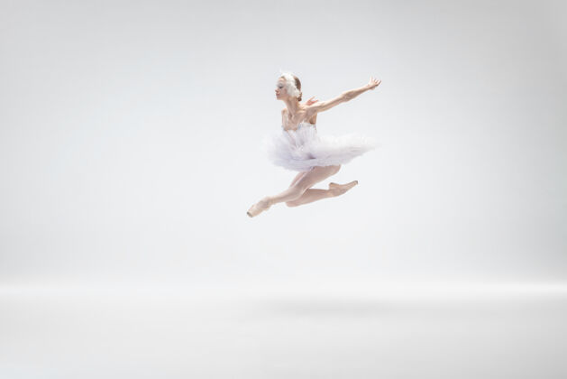 当代以白色工作室为背景的年轻优雅的芭蕾舞演员年轻喜悦动作