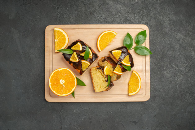 食物黑色背景上新鲜柠檬片和切碎蛋糕片的俯视图新鲜美味午餐