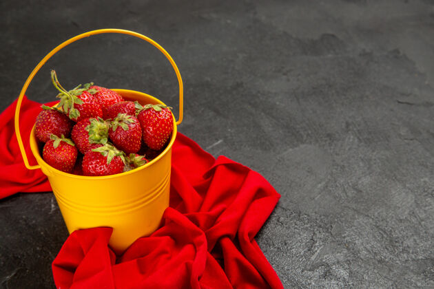 可食用的水果前视图新鲜的红色草莓在一个黑暗的背景小篮子里深色浆果多汁