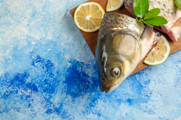 食物俯视图浅蓝色表面柠檬切片鲜鱼海洋水海