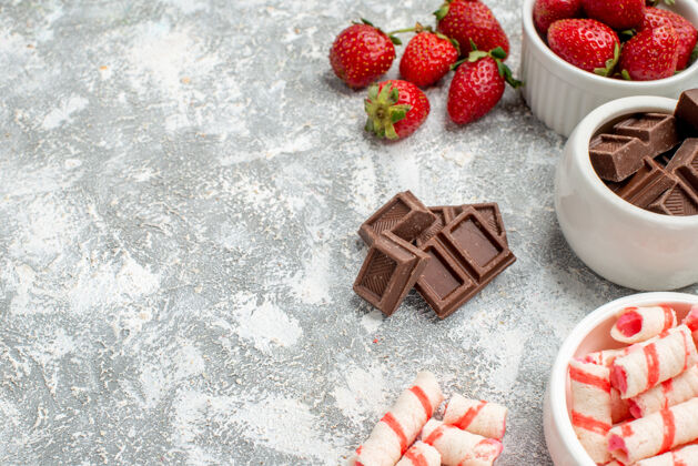 甜点在灰白色马赛克背景的右侧 下半部分是草莓巧克力糖果和一些草莓巧克力糖果的碗浆果食物底部