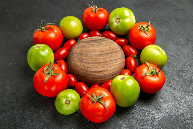水果底部视图樱桃红色和绿色的西红柿围绕着一个木制盘子在黑暗的地面上蔬菜木头健康的