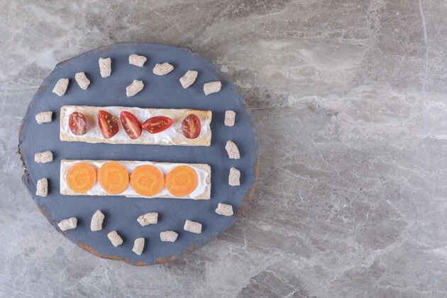 面筋胡萝卜片 西红柿面包片 面包屑包在木板上 大理石表面年糕美味大米