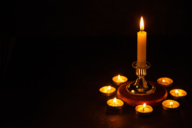 风景燃烧的蜡烛的正面视图 作为坠落黑暗表面的记忆燃烧倒下烛台