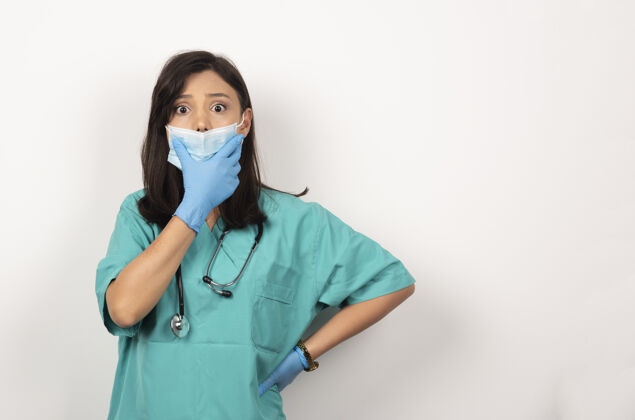 医疗戴着医用面罩和手套的年轻医生在白色背景上摆姿势高质量照片面罩女性站立