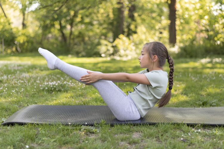在家在瑜伽垫上锻炼的全镜头女孩健身孩子运动