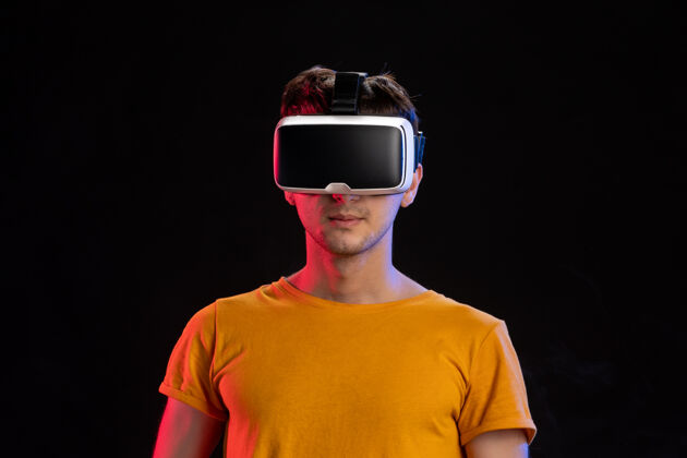 游戏帅哥戴着虚拟现实耳机在黑暗的表面男性人游戏