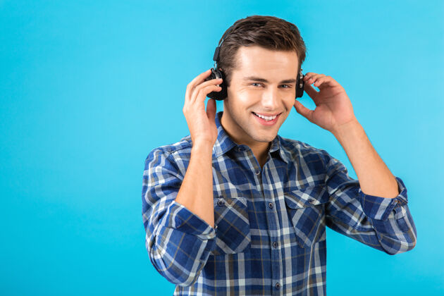 自信坐在蓝色耳机上听音乐的男人的画像男人乐趣时髦