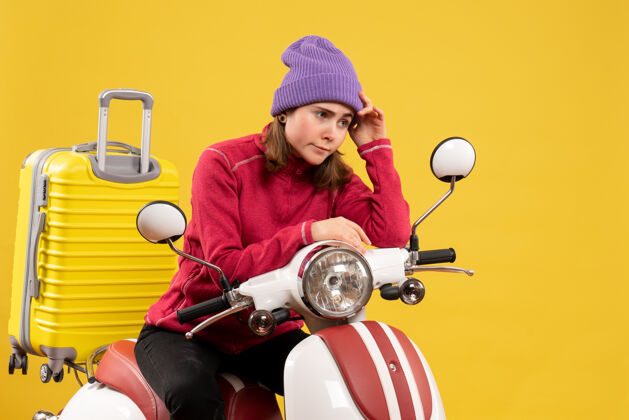 前面前面的景色让那个戴着紫色帽子坐在轻便摩托车上的年轻女孩心烦意乱成人坐着轻便摩托车