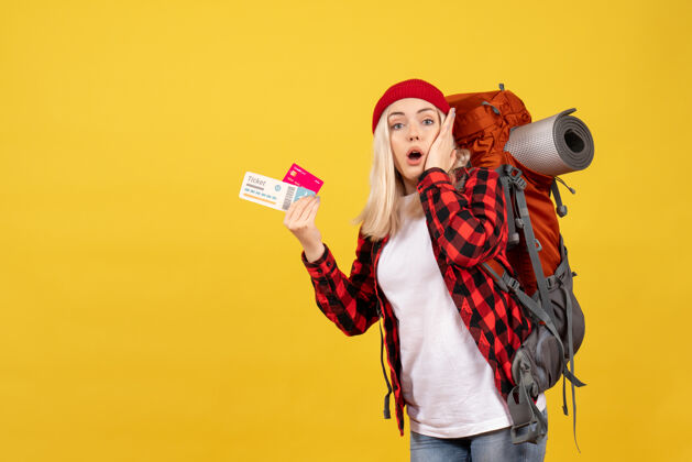 背包正面图：一个金发女孩背着背包 手里拿着名片和旅行票成人前面持有