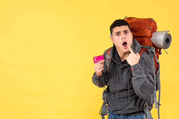 背包正面图惊讶的旅行者男子背着红色背包拿着信用卡男男视图