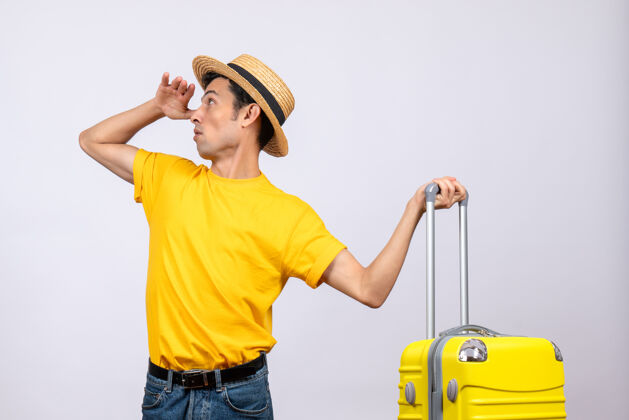 休闲正面图年轻的游客站在黄色的手提箱旁边 看着拿着手提箱的东西清洁站黄
