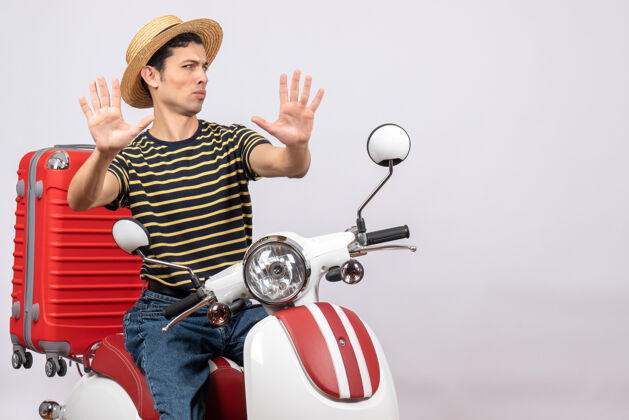 男人一个戴着草帽的年轻人坐在轻便摩托车上做停车标志帽子摩托车稻草