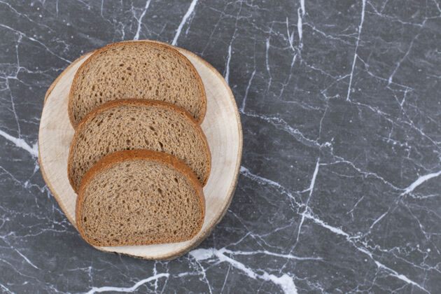 谷物切好的黑麦面包放在切菜板上 放在灰面包上新鲜自然健康