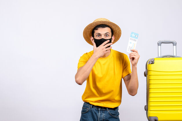 站立正面图：穿着黄色t恤的男性游客站在黄色手提箱旁举着旅行票旅行人男性