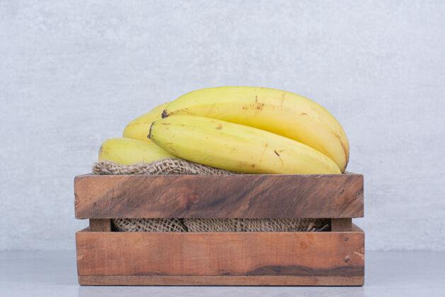 木材一个装满成熟水果的木篓香蕉上的白色香蕉黄色一串