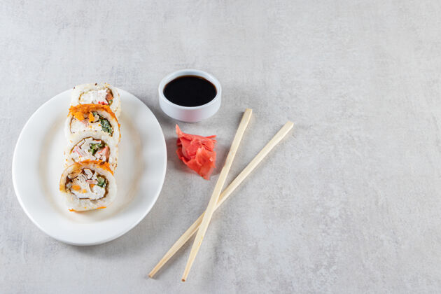 卷白色盘子 石底有寿司卷和酱油Nigiri什锦健康