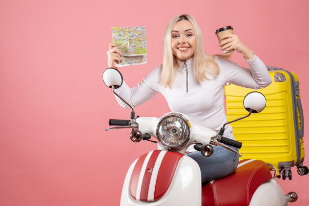 咖啡正面图微笑的年轻女士手持咖啡杯和地图坐在轻便摩托车上地图女人微笑